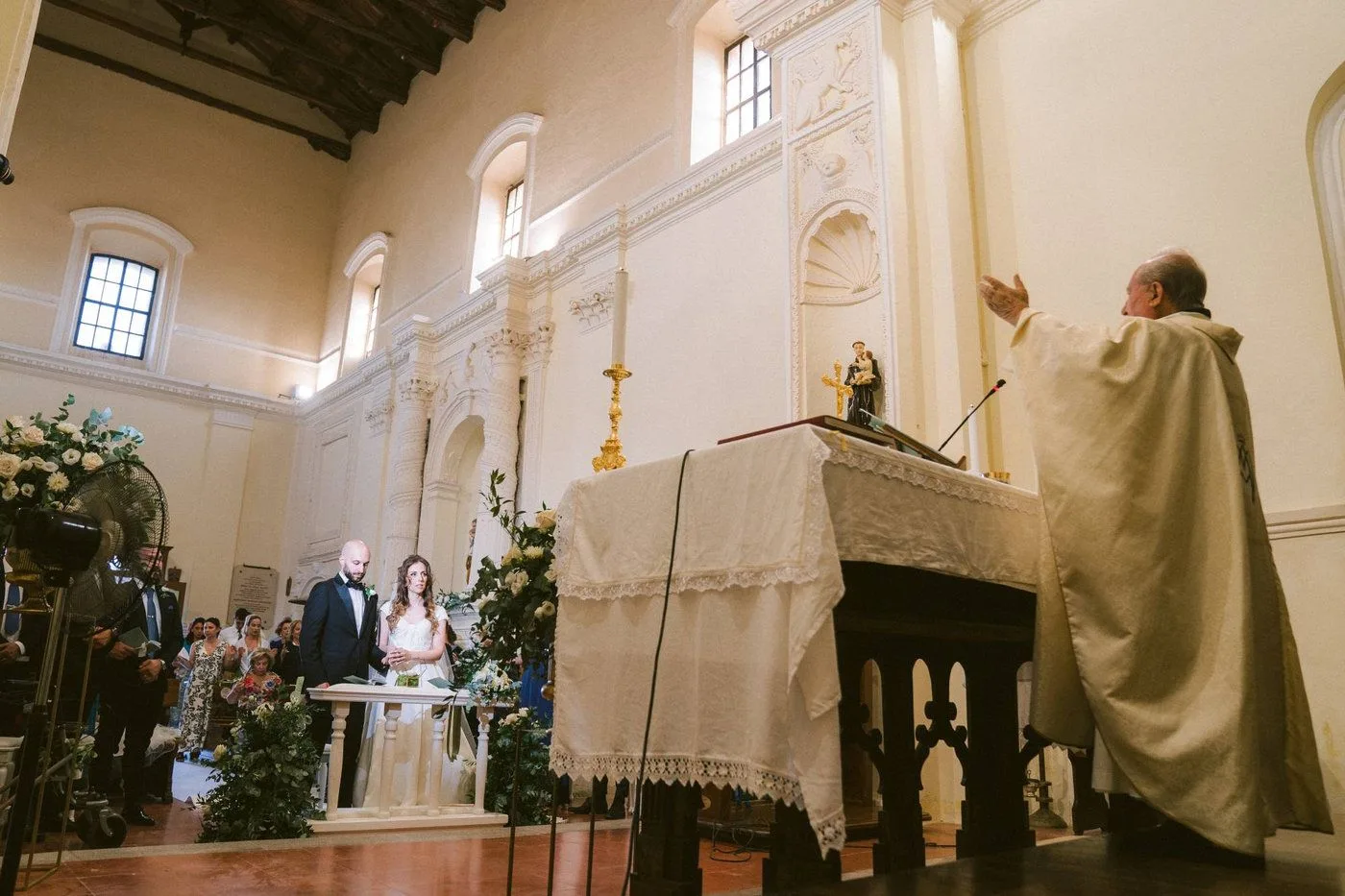 Una coppia di sposi sull'altare riceve la benedizione del prete durante la funzione del matrimonio presso la chiesa di Santa Ruba in Vibo valentia · foto 8